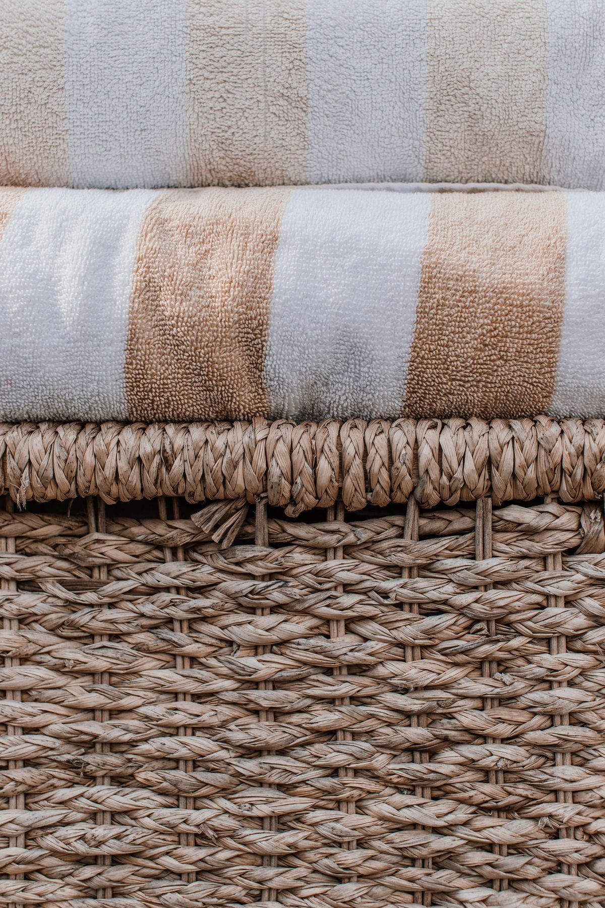 Folded towels on a woven laundry basket
